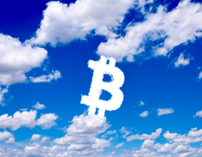 Bitcoin sign in clouds form with blue sky background