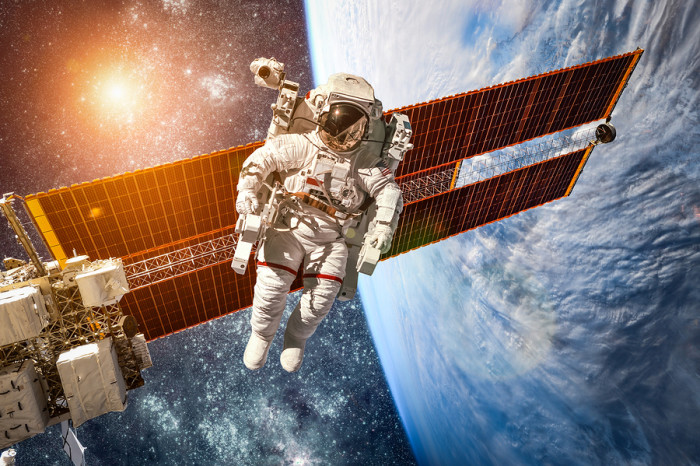 International Space Station and astronaut in outer space over the planet Earth. Elements of this image furnished by NASA.