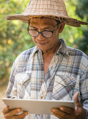 Old man with glasses and hat holding a tablet