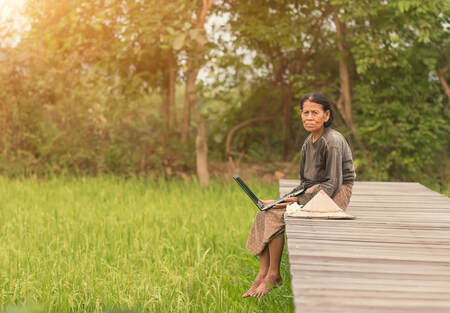 Old lady sitting outside with laptop